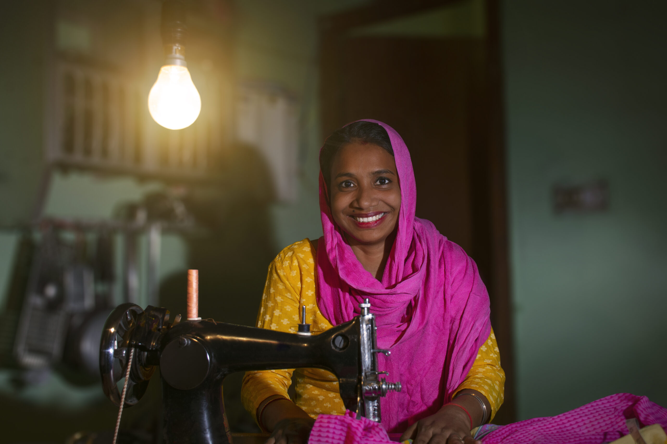 PORTRAIT OF A RURAL WOMAN SEWING CLOTHES