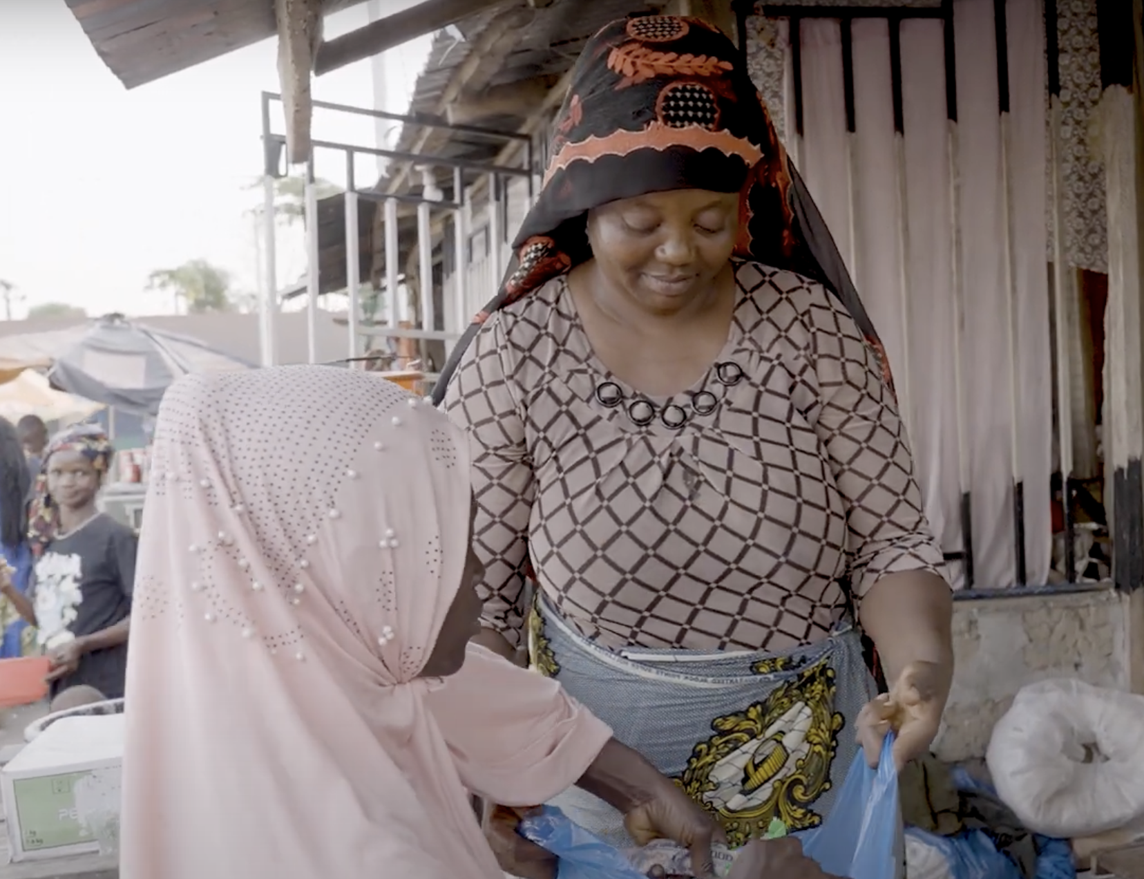 Woman entrepreneur opens bag for woman client.