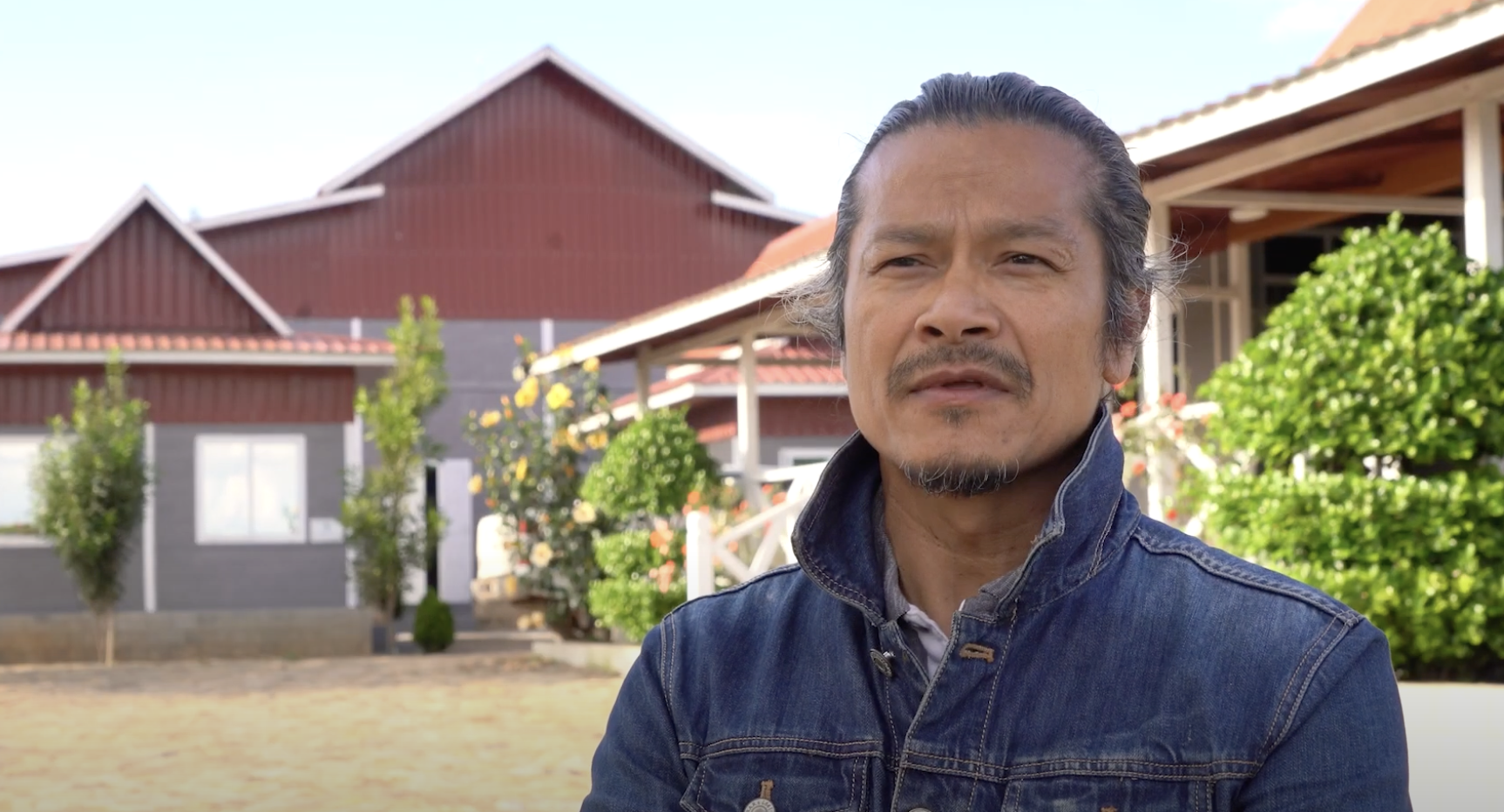 Man with farm in background.