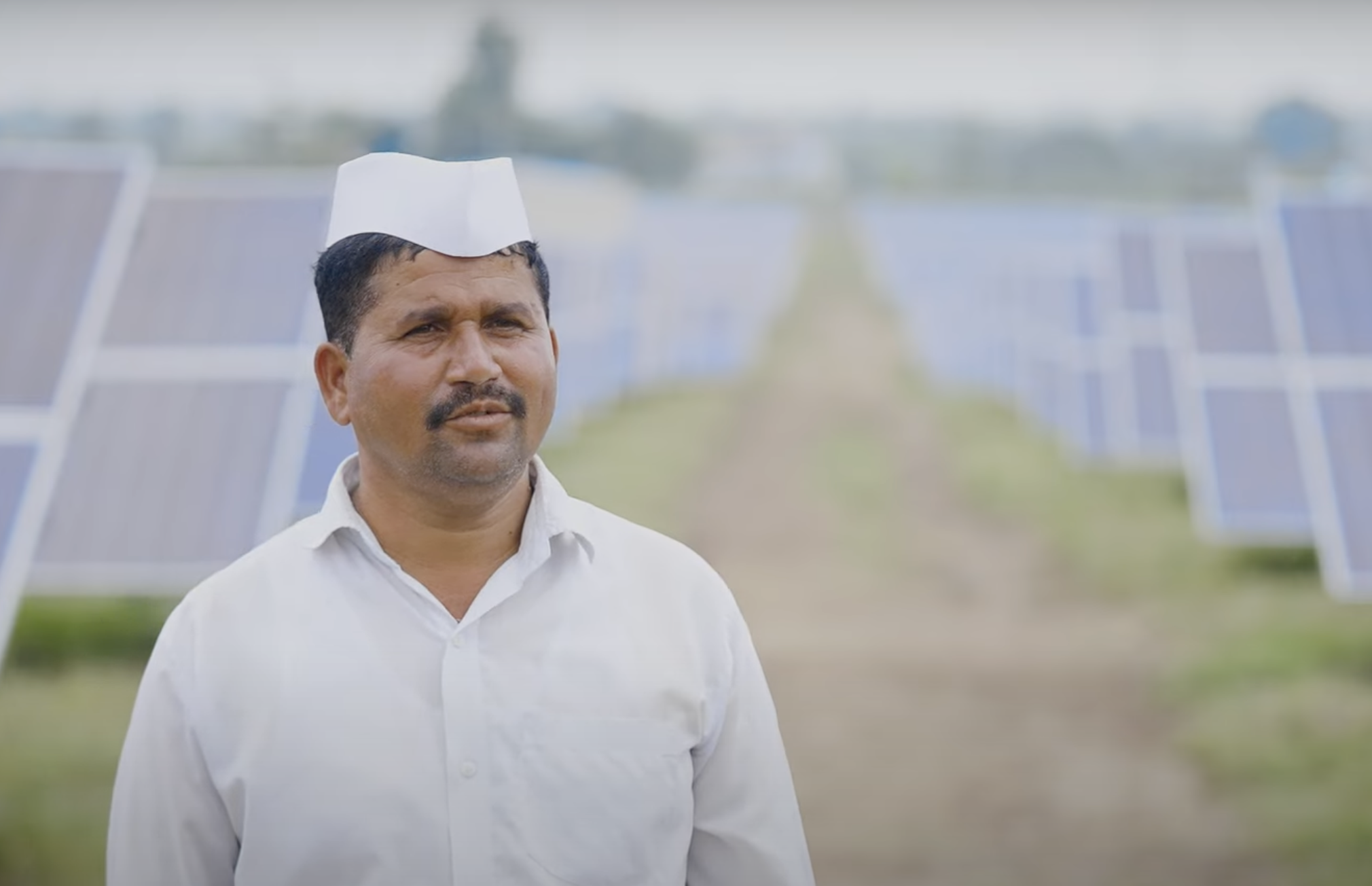 Man stands in front of solar panels
