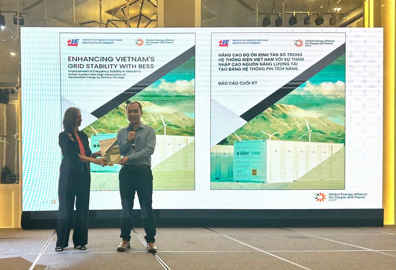 two people on stage holding a report
